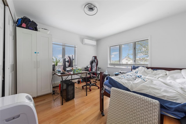 628 151st St, Whitestone, NY 11357 - bedroom featuring a wall mounted AC, multiple windows, light wood-style flooring, and a desk