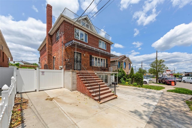 628 151st St, Whitestone, NY 11357 - view of front of property featuring brick siding, a chimney, a gate, and driveway