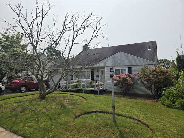 65 Birchfield Ave, Babylon, NY 11702 - view of front of property with a front lawn, a chimney, and metal roof