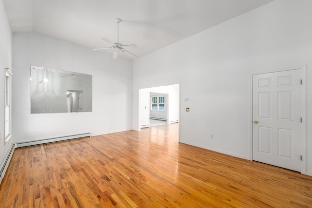 67 Fairway Dr, Wading River, NY 11792 - unfurnished living room with a ceiling fan, wood finished floors, baseboard heating, and high vaulted ceiling