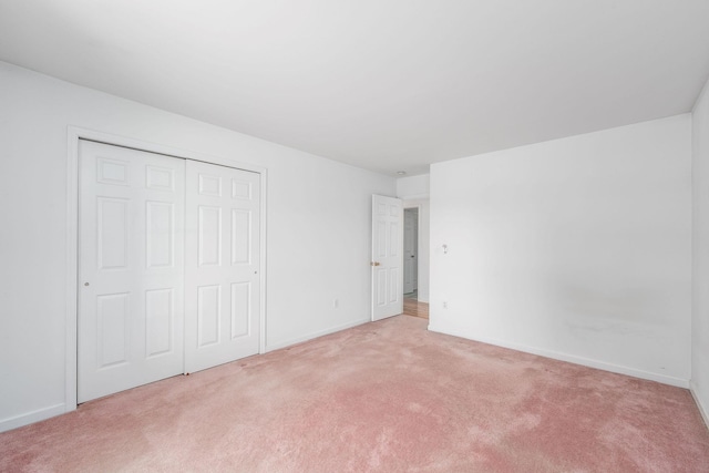 67 Fairway Dr, Wading River, NY 11792 - unfurnished bedroom featuring light colored carpet, a closet, and baseboards