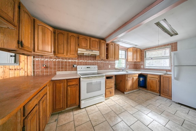 3 Avenue E, Godeffroy, NY 12729 - kitchen with white appliances, under cabinet range hood, decorative backsplash, brown cabinetry, and light tile patterned floors