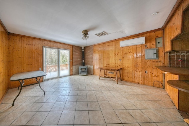 3 Avenue E, Godeffroy, NY 12729 - living area featuring a wood stove, wooden walls, a wall mounted air conditioner, light tile patterned flooring, and a ceiling fan
