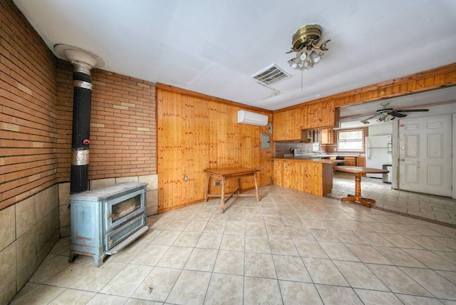 3 Avenue E, Godeffroy, NY 12729 - kitchen with freestanding refrigerator, a wood stove, a peninsula, wooden walls, and light tile patterned floors