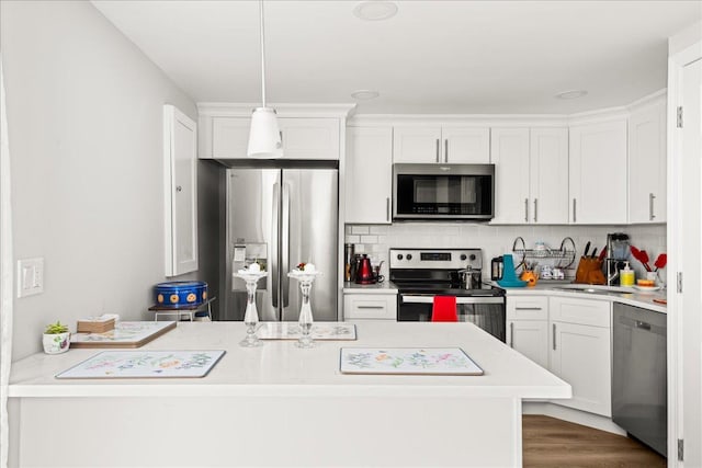 109 Silverleaf Ln, Islandia, NY 11749 - kitchen with stainless steel appliances, light countertops, backsplash, white cabinetry, and dark wood-type flooring