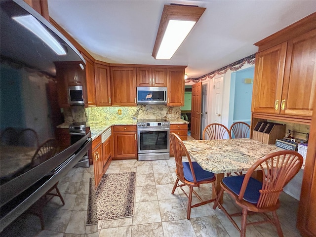 3 Johnston Rd, Livingston Manor, NY 12758 - kitchen featuring stainless steel appliances, backsplash, brown cabinetry, and light stone counters