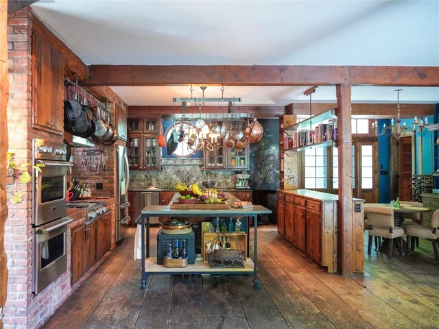 501 Guard Hill Rd, Bedford, NY 10506 - kitchen featuring dark wood finished floors, appliances with stainless steel finishes, beamed ceiling, glass insert cabinets, and a chandelier