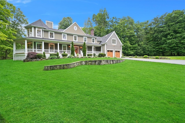 383 Illington Rd, Ossining, NY 10562 - view of front of property with covered porch, an attached garage, concrete driveway, a chimney, and a front lawn
