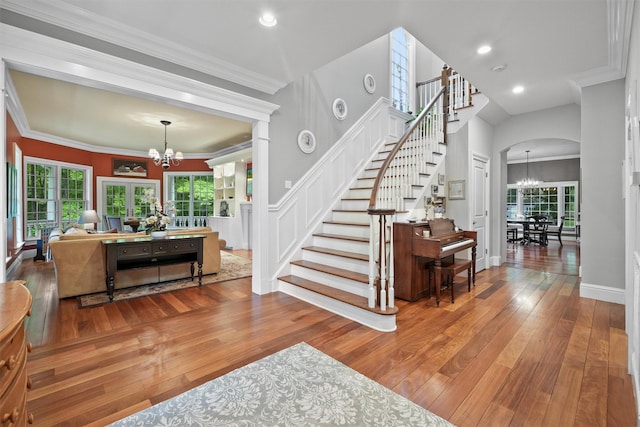 383 Illington Rd, Ossining, NY 10562 - entrance foyer with a chandelier, stairway, wood-type flooring, arched walkways, and crown molding