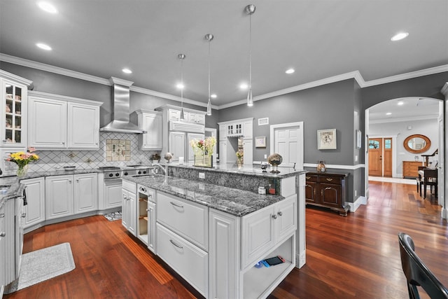 383 Illington Rd, Ossining, NY 10562 - kitchen with wall chimney range hood, arched walkways, white cabinetry, recessed lighting, and crown molding