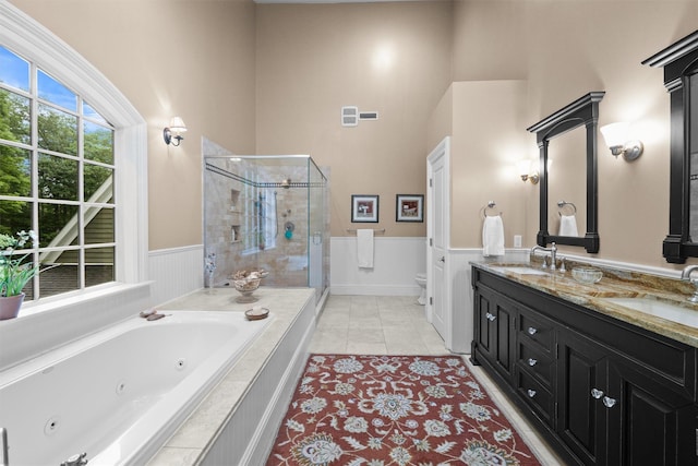 383 Illington Rd, Ossining, NY 10562 - full bathroom featuring a stall shower, a jetted tub, double vanity, wainscoting, and tile patterned flooring