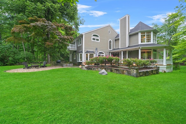 383 Illington Rd, Ossining, NY 10562 - rear view of property with a chimney, a yard, a balcony, and a fire pit
