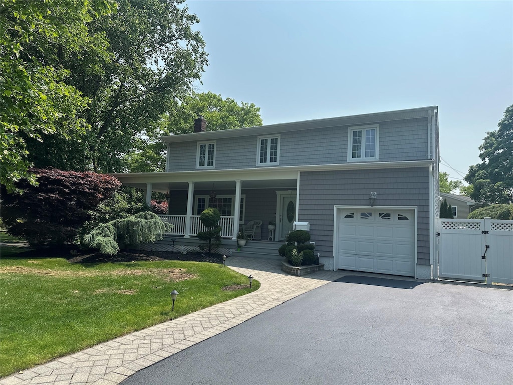 43 Clafford Ln, Melville, NY 11747 - view of front of house with a porch, a chimney, a garage, a gate, and driveway