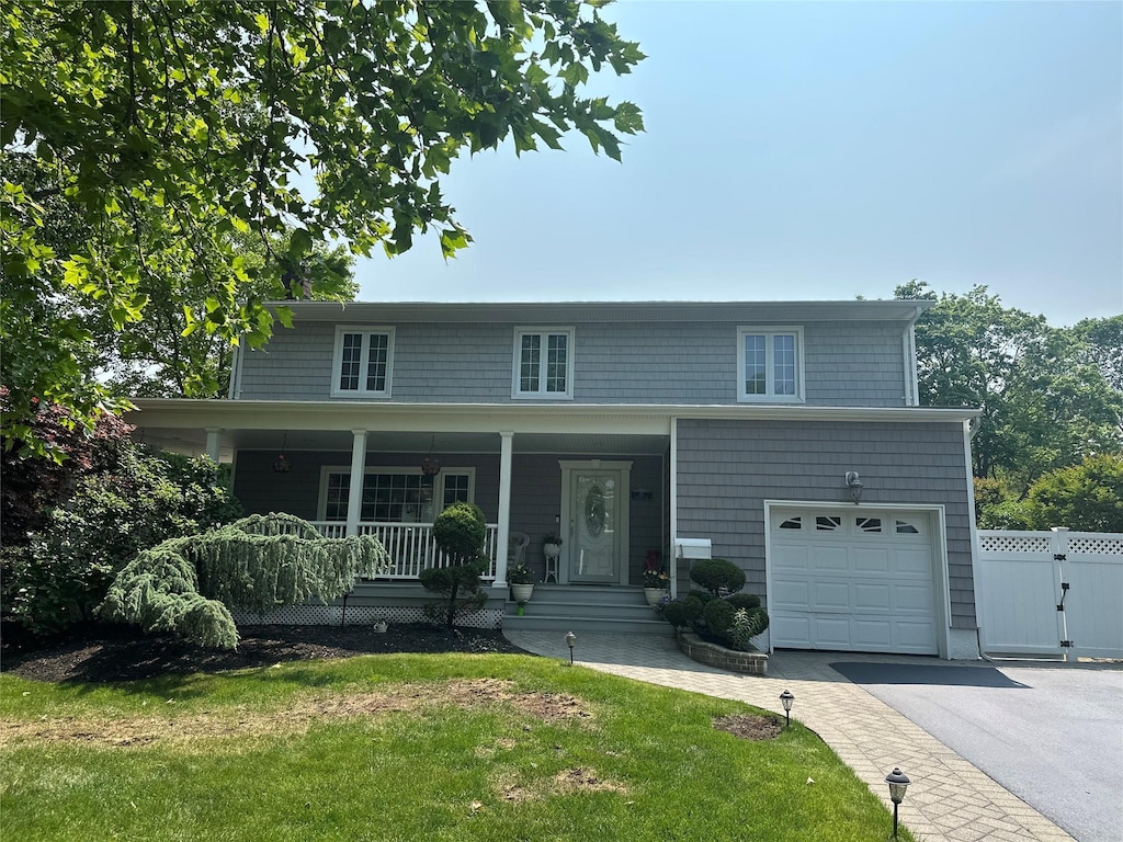 43 Clafford Ln, Melville, NY 11747 - view of front of house featuring a garage, covered porch, driveway, and a gate