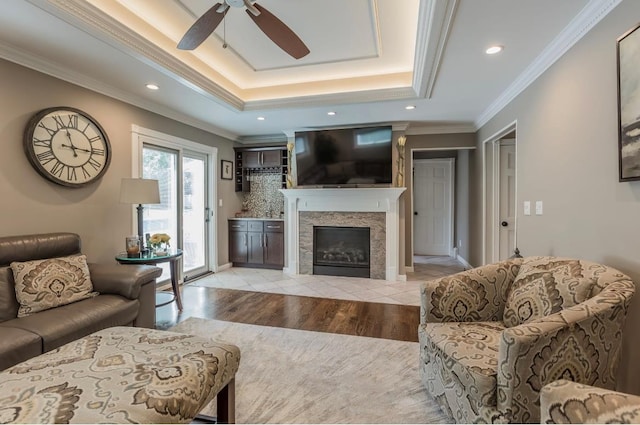 10 Woods Edge Ct, Hauppauge, NY 11788 - living room featuring ceiling fan, light wood-style flooring, a tray ceiling, crown molding, and a tile fireplace