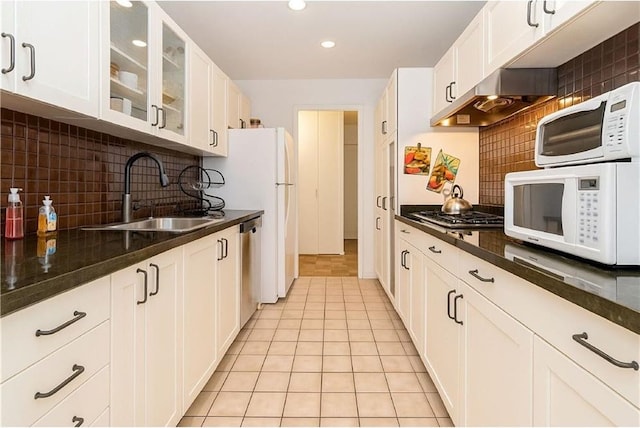 40 Brighton 1st Rd Unit 12H, Brooklyn, NY 11235 - kitchen with appliances with stainless steel finishes, a sink, wall chimney exhaust hood, glass insert cabinets, and recessed lighting