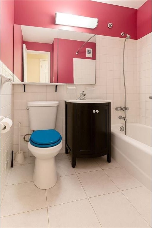 40 Brighton 1st Rd Unit 12H, Brooklyn, NY 11235 - bathroom featuring tile walls, tile patterned floors, toilet, bathing tub / shower combination, and vanity