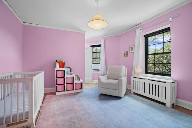 295 N Broadway Unit 27, Yonkers, NY 10701 - bedroom with radiator heating unit, baseboards, ornamental molding, wood finished floors, and a nursery area