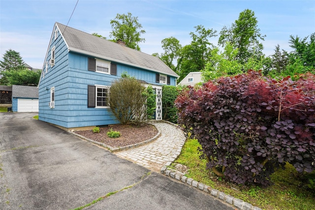 329 Simpson Pl, Peekskill, NY 10566 - view of side of property with an outbuilding, a chimney, a garage, and a shingled roof