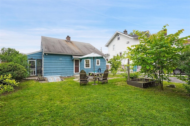 329 Simpson Pl, Peekskill, NY 10566 - rear view of house with a garden, a yard, and a chimney