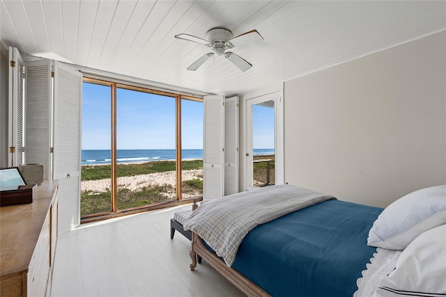 0 Atlantic Walk, Water Island, NY 11772 - bedroom with a wall of windows, view of water and beach, multiple windows, wood finished floors, and ceiling fan