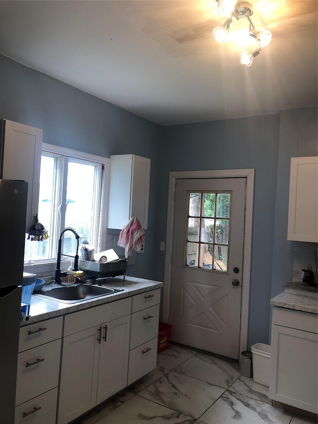 19 Wawayanda Ave, Middletown, NY 10940 - kitchen with freestanding refrigerator, a sink, light marble finish floors, and white cabinets