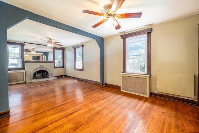2430 Loft Ave, Baldwin, NY 11510 - unfurnished living room with radiator, a ceiling fan, wood-type flooring, and plenty of natural light