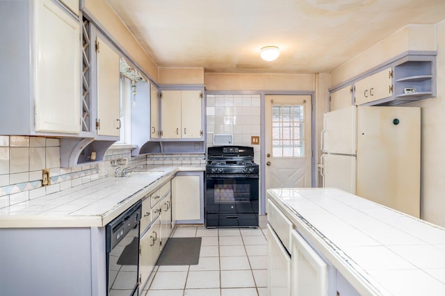 2430 Loft Ave, Baldwin, NY 11510 - kitchen with black gas stove, dishwashing machine, freestanding refrigerator, open shelves, and tile countertops