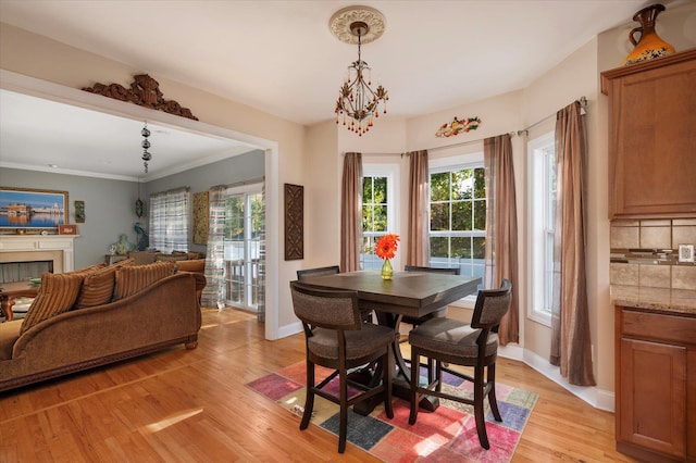 2 Undset Ct, Dix Hills, NY 11746 - dining space featuring light wood finished floors, healthy amount of natural light, crown molding, and a fireplace