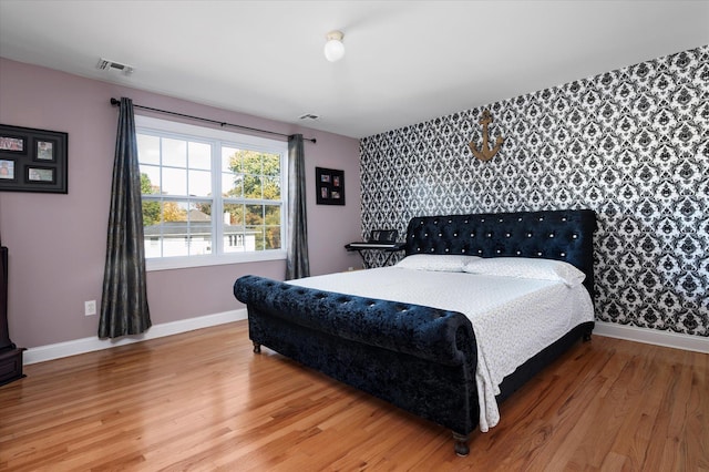 2 Undset Ct, Dix Hills, NY 11746 - bedroom featuring an accent wall, wallpapered walls, and wood finished floors