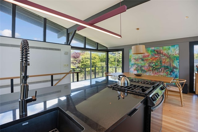 490 Tarpon Walk, Fire Island Pines, NY 11782 - kitchen with range with gas stovetop, a sink, dark stone counters, expansive windows, and light wood-style floors