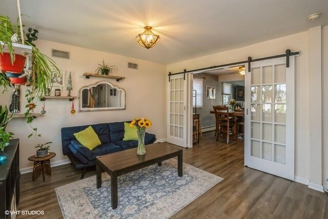 2976 Ruth Rd, Wantagh, NY 11793 - living room with a barn door, wood finished floors, baseboards, and plenty of natural light