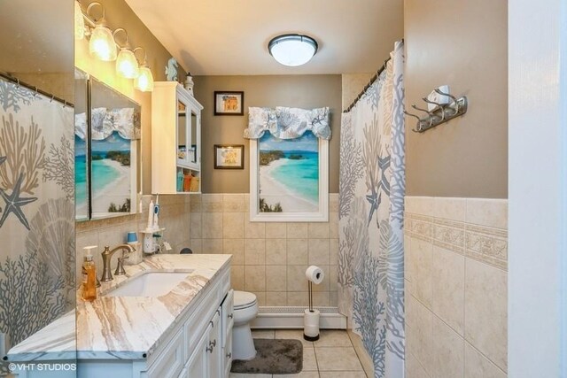 2976 Ruth Rd, Wantagh, NY 11793 - full bath with tile walls, tile patterned floors, toilet, vanity, and a wainscoted wall