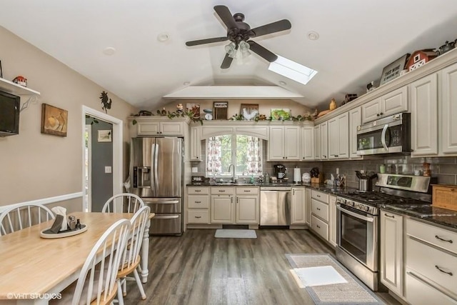 2976 Ruth Rd, Wantagh, NY 11793 - kitchen with stainless steel appliances, a sink, a skylight, a ceiling fan, and vaulted ceiling