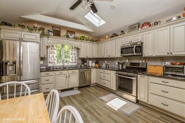 2976 Ruth Rd, Wantagh, NY 11793 - kitchen with appliances with stainless steel finishes, a ceiling fan, a sink, a skylight, and light wood-style floors