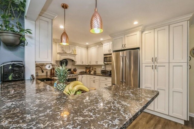 2976 Ruth Rd, Wantagh, NY 11793 - kitchen with stainless steel appliances, a sink, tasteful backsplash, a peninsula, and pendant lighting