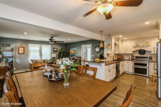 2976 Ruth Rd, Wantagh, NY 11793 - dining room with a ceiling fan, dark wood-type flooring, recessed lighting, and a baseboard heating unit