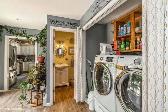 2976 Ruth Rd, Wantagh, NY 11793 - laundry area with washer and clothes dryer and light wood finished floors