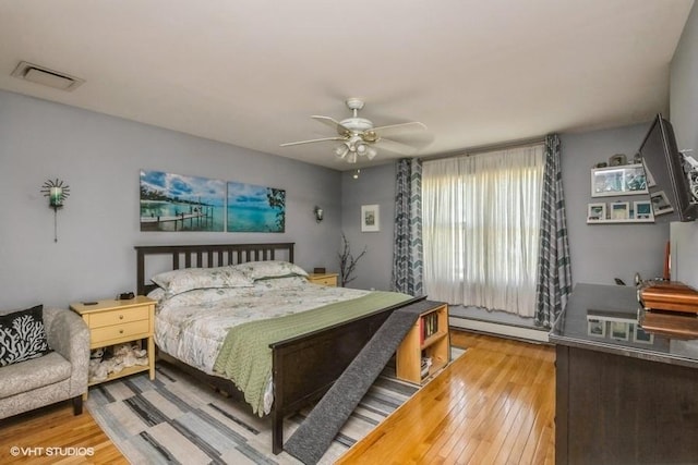 2976 Ruth Rd, Wantagh, NY 11793 - bedroom featuring baseboard heating, light wood-type flooring, and a ceiling fan