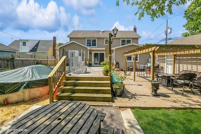 2976 Ruth Rd, Wantagh, NY 11793 - rear view of property with a pergola, a wooden deck, a patio, an outdoor fire pit, and a chimney