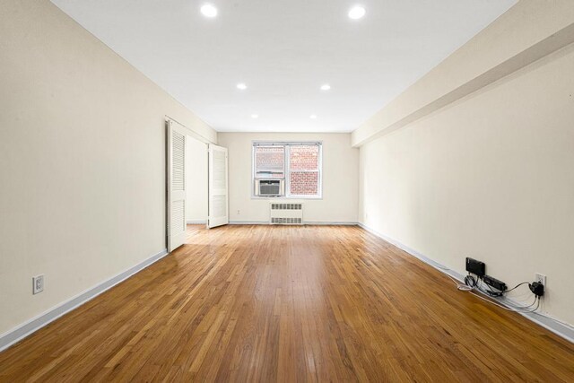 72-10 112th St Unit 5B, Forest Hills, NY 11375 - spare room with radiator heating unit, light wood-style floors, recessed lighting, baseboards, and cooling unit