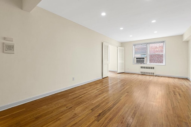 72-10 112th St Unit 5B, Forest Hills, NY 11375 - spare room with radiator, light wood-style floors, baseboards, recessed lighting, and cooling unit