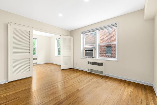 72-10 112th St Unit 5B, Forest Hills, NY 11375 - unfurnished room featuring radiator heating unit, light wood-type flooring, baseboards, cooling unit, and recessed lighting