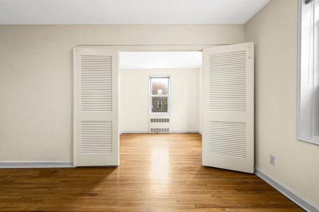 72-10 112th St Unit 5B, Forest Hills, NY 11375 - unfurnished room featuring radiator heating unit, wood finished floors, and baseboards