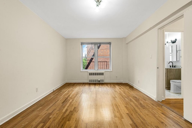 72-10 112th St Unit 5B, Forest Hills, NY 11375 - spare room featuring radiator, wood-type flooring, and baseboards