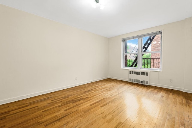 72-10 112th St Unit 5B, Forest Hills, NY 11375 - unfurnished room featuring radiator, hardwood / wood-style floors, and baseboards