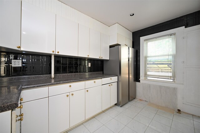 43-24 219th St, Bayside, NY 11361 - kitchen with freestanding refrigerator, white cabinetry, dark countertops, and light tile patterned floors