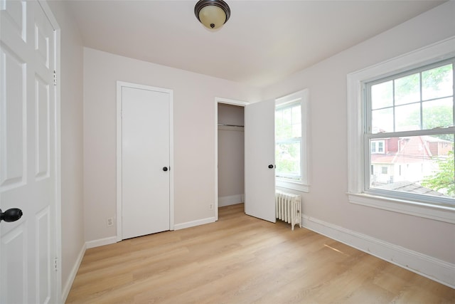 43-24 219th St, Bayside, NY 11361 - unfurnished bedroom with radiator heating unit, light wood-style floors, and baseboards