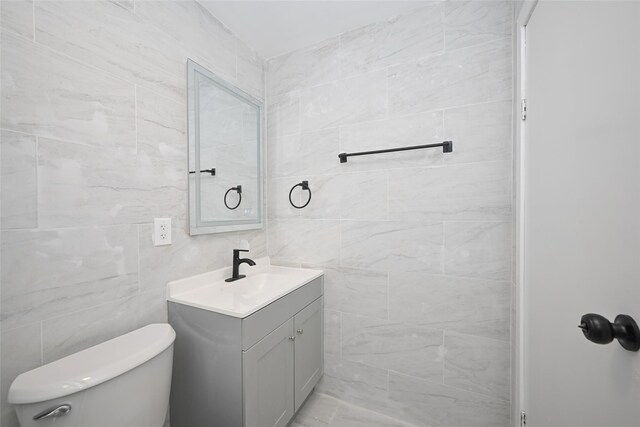 43-24 219th St, Bayside, NY 11361 - bathroom featuring vanity, toilet, and tile walls