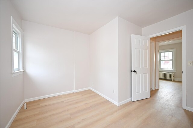 43-24 219th St, Bayside, NY 11361 - empty room featuring radiator, light wood-style floors, and baseboards